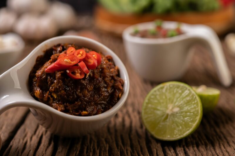 Red Eye Chili Paste with Lemon and Chili on Wooden Floor