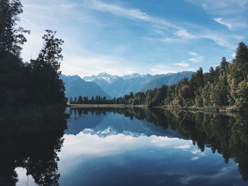 Reflection of trees and sky in lake in New Zealand