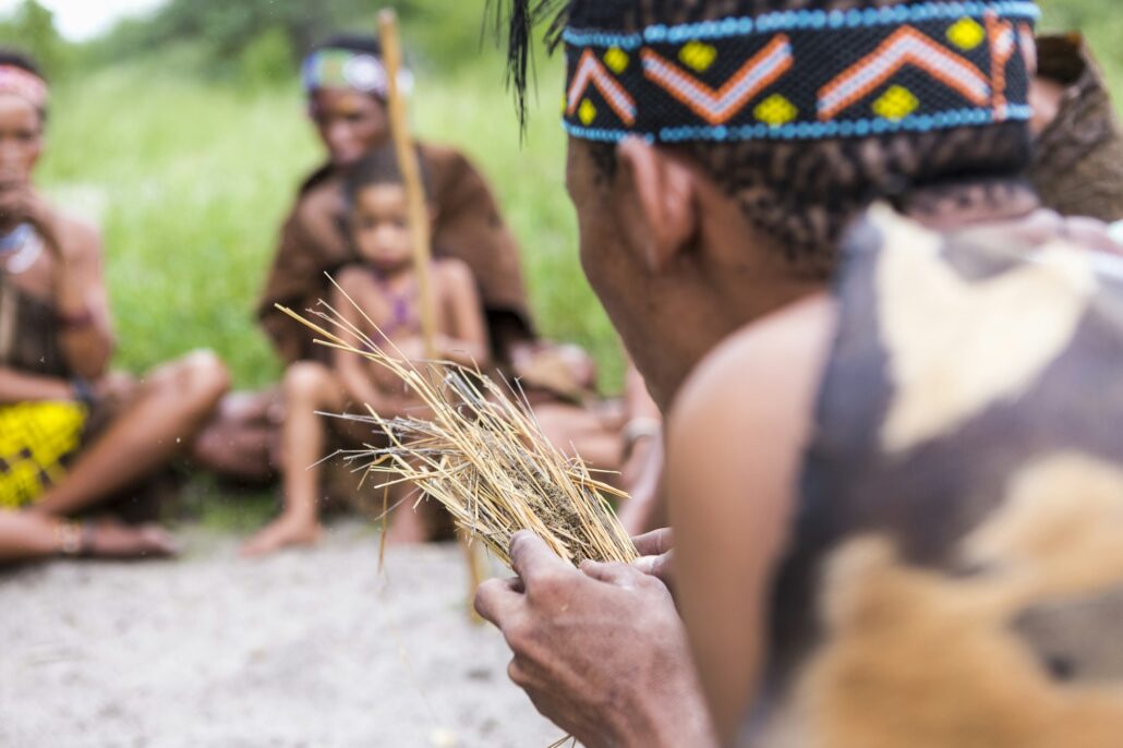 San People, a bushman creating fire from dry kindling, a cultural demonstration.