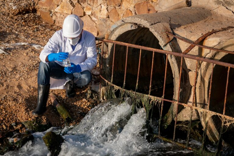 Scientist wearing protective uniform and glove under working water analysis and water quality by get