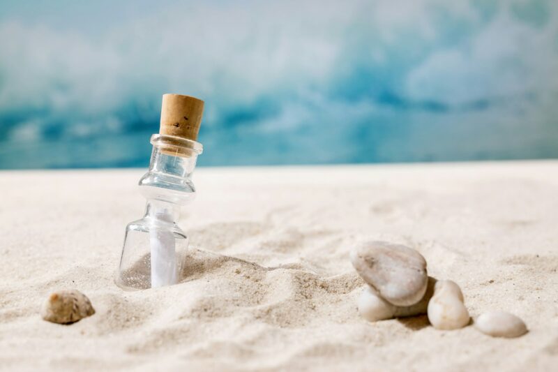 Summer sand sea beach with waves and glass botle with message