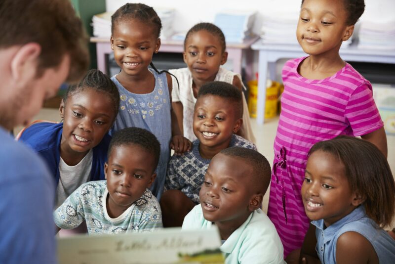 Teacher reading book to elementary school children in class