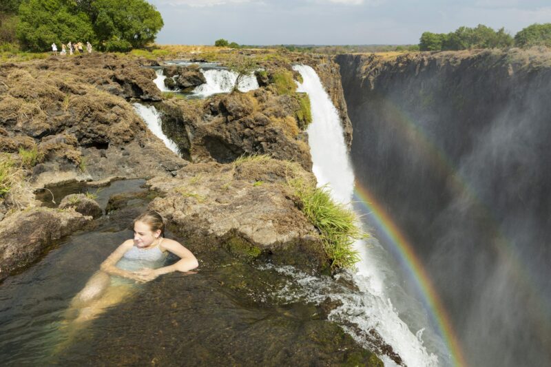 Teenage girl in the water at the Devils Pool, on the cliff top overlooking Victoria Falls, Zambia.