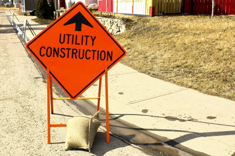 Temporary utility construction ahead sign beside a sidewalk