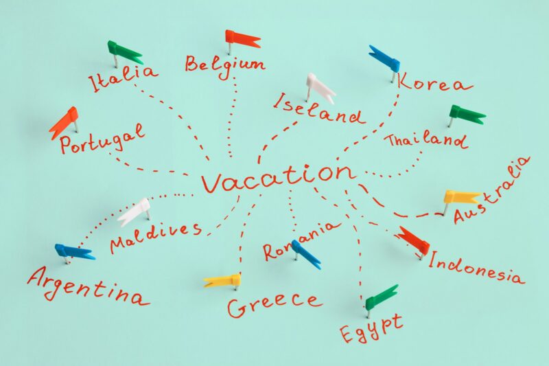 The inscription "vacation" and names of countries marked with pins. Concept of travel planning