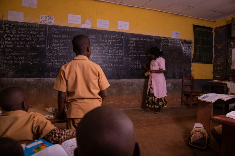 the questioned child stands and the teacher writes his answer on the blackboard