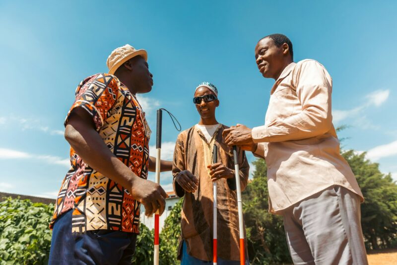 Three blind men are holding a conversation together, friendship between disabled people