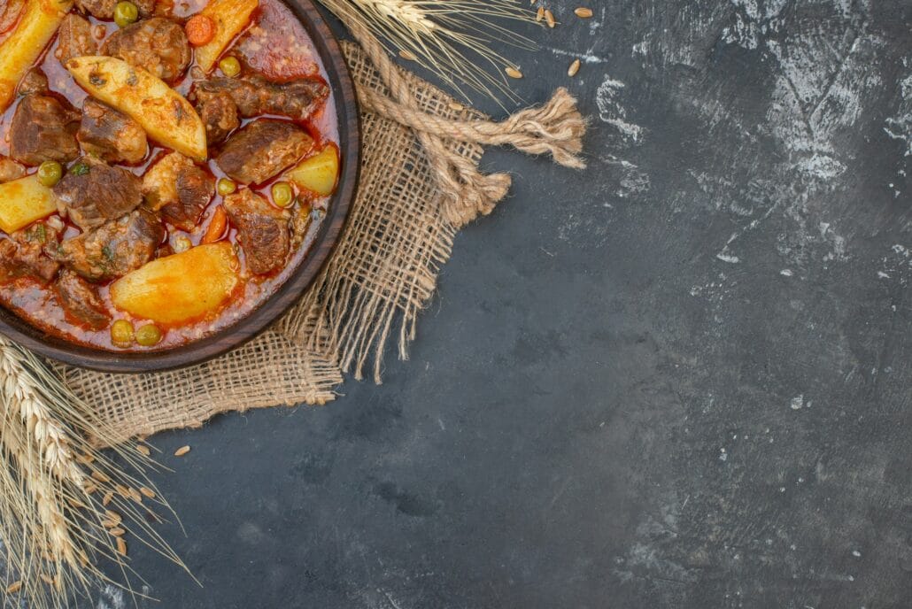 top view bozbash meat soup in wooden bowl on grey background with copy place