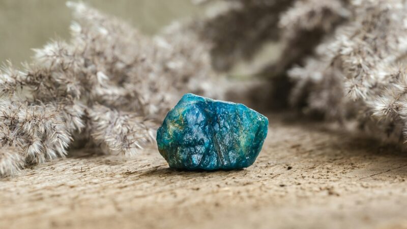 Tumbled Blue Apatite Crystal Gemstone on Wood