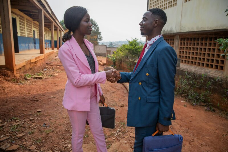 Two african business people shake hands, are smartly dressed, business colleagues in agreement.