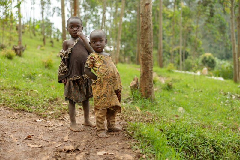Two African children standing in the forest