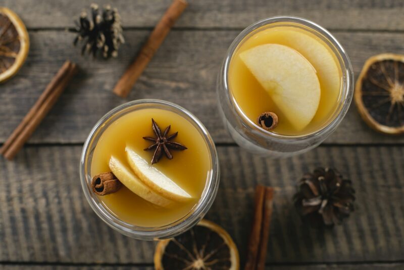 Two glasses with apple cidr on wooden table background. Winter hot Beverage. Top view