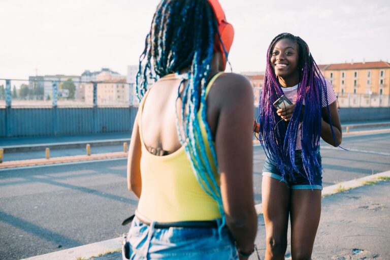 two women sisters outdoor listening music dancing