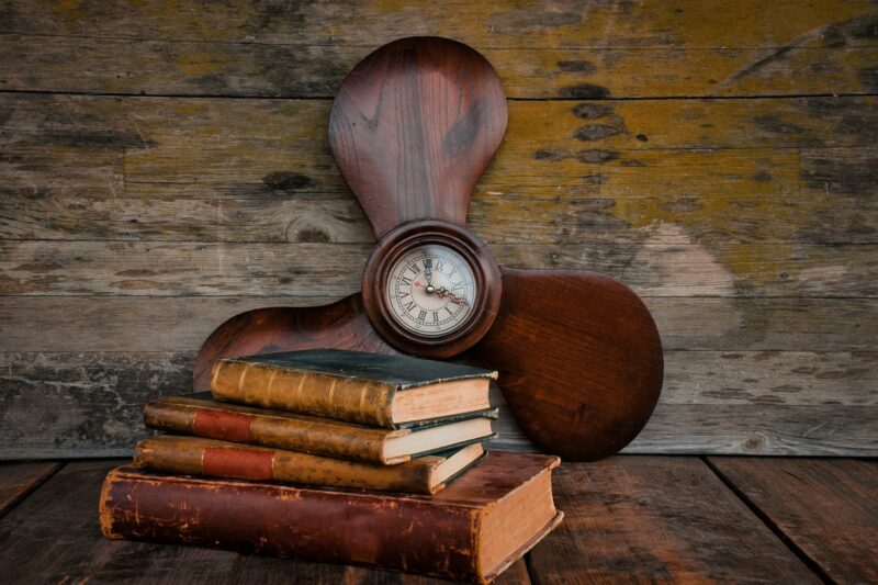 Vintage and original helix-shaped clock and several old books. Memory, time, history, nostalgia.