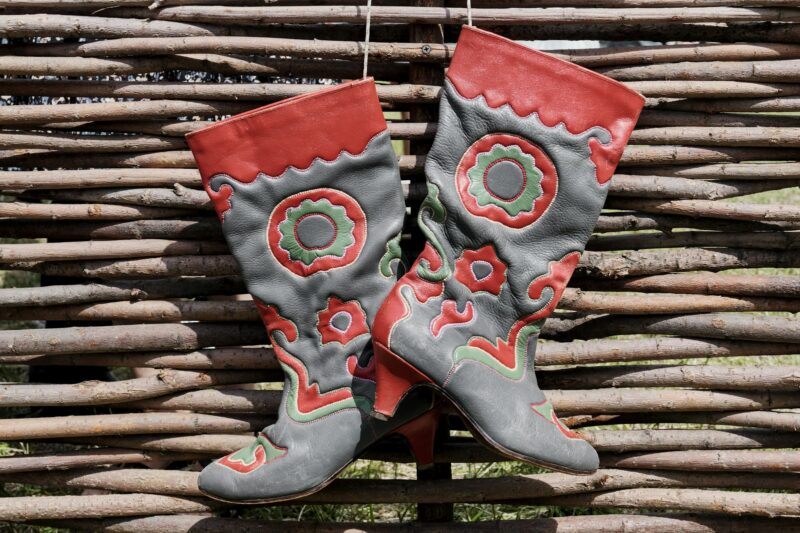 Vintage traditional Tatar leather boots, decorated with mosaic floral pattern, hanging on wattle