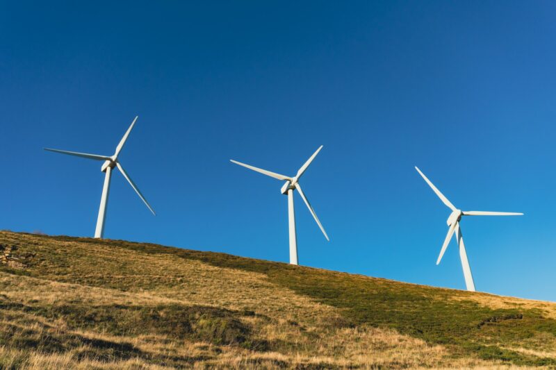 Wind turbines in a wind farm to get clean green energy through the air on top of a mountain
