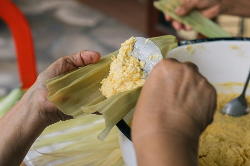 Woman's hands preparing traditional Peruvian corn-based food called Humita