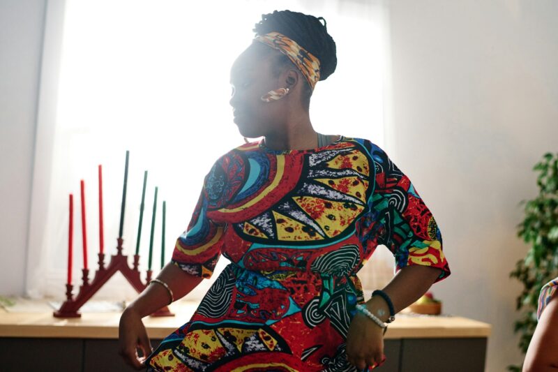 Young African American woman in ethnic attire and accessories performing dance