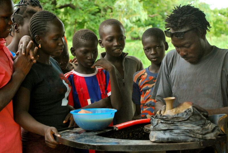 Young african streeft children taking a pottery course - reeducation volunteering