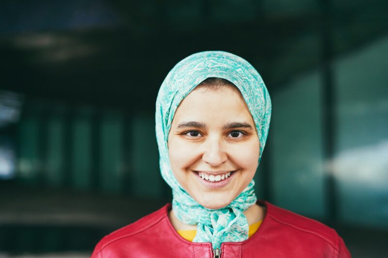 Young arabian girl smiling at camera outdoor - Focus on eyes