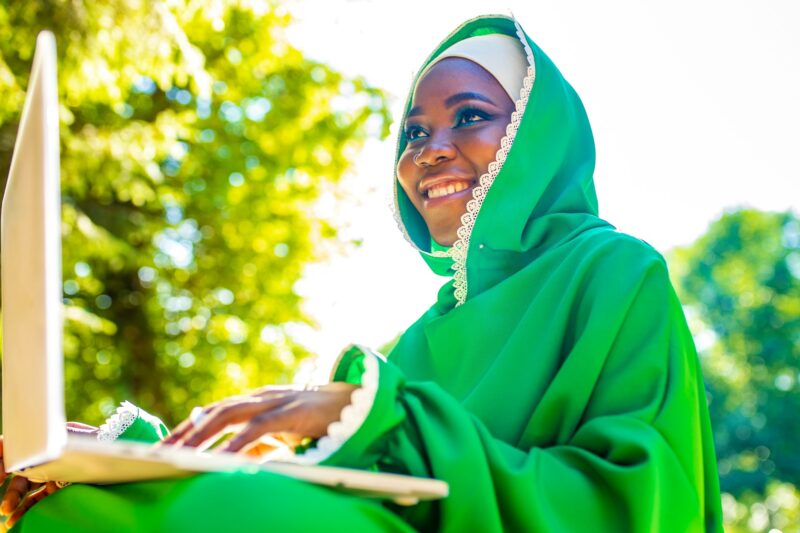 young beautiful muslim business woman with modern make up wear green hijab and useing laptop while