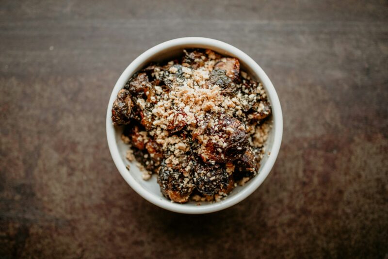 a white bowl filled with food on top of a wooden table