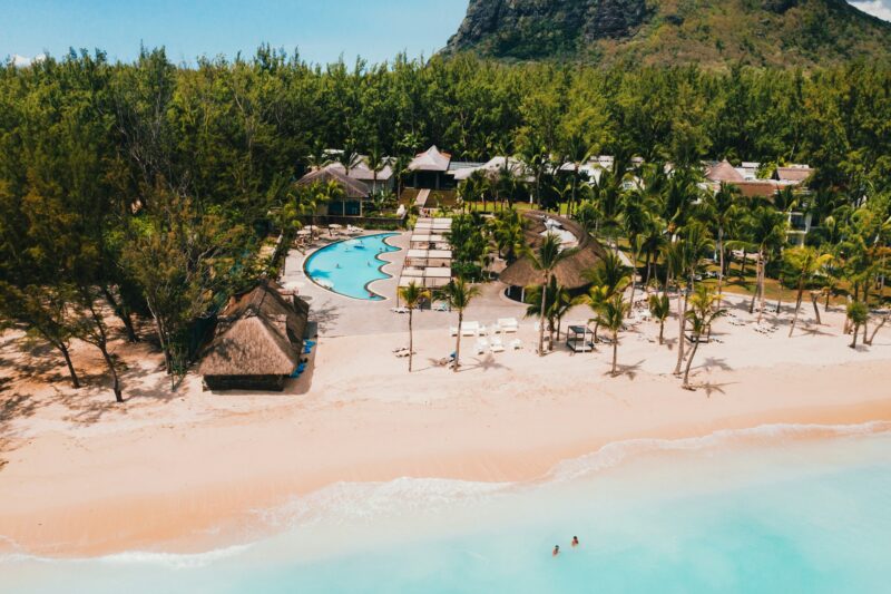 A bird's-eye view of the beach near the resort and the ocean next to mount Le Morne Brabant