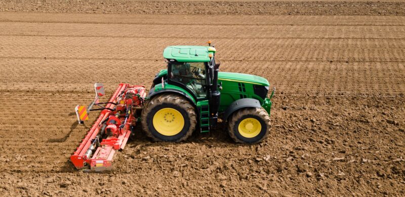 A farmer using a tractor to prepare the fields for planting. The image highlights the importance of