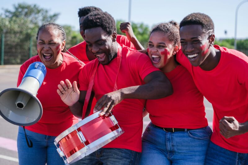 African American cheer group together cheering their team on their way to the world cup