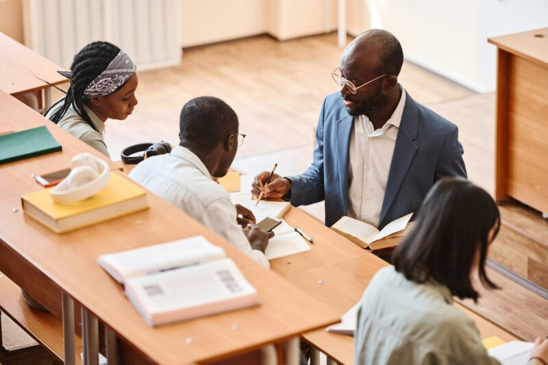 African teacher working with students at lecture