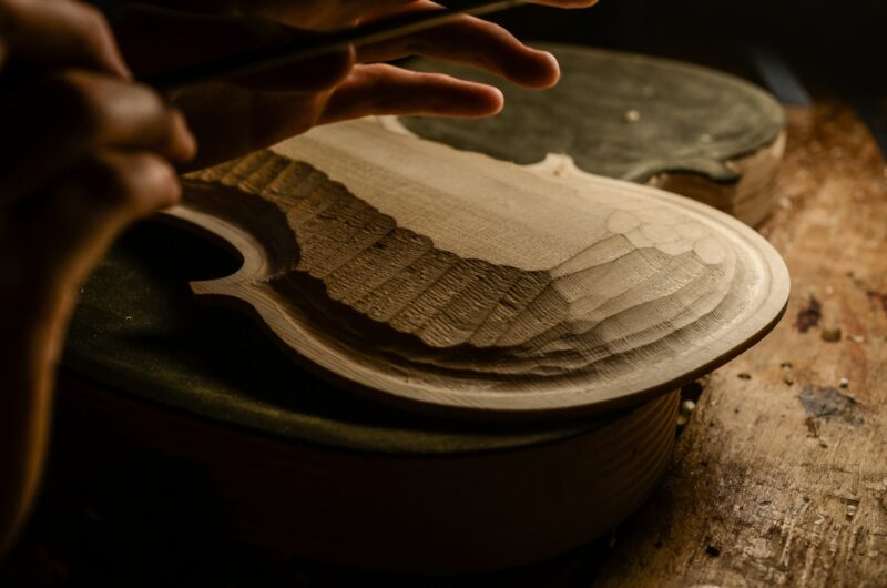 Artisan woman violin maker luthier working in a new violin