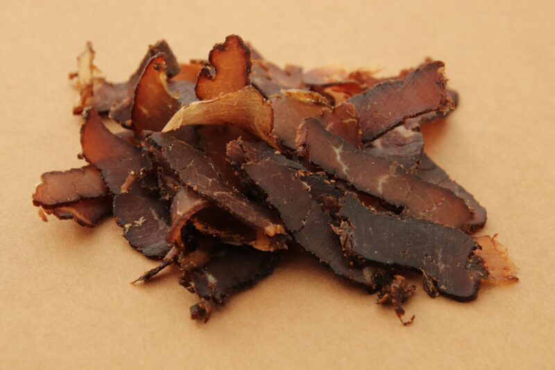 Biltong (dried meat) on a wooden board, this is a traditional food snack in South Africa.
