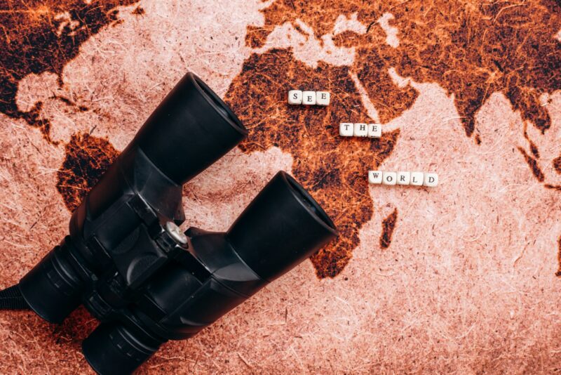Black binoculars lies on the a geographical map