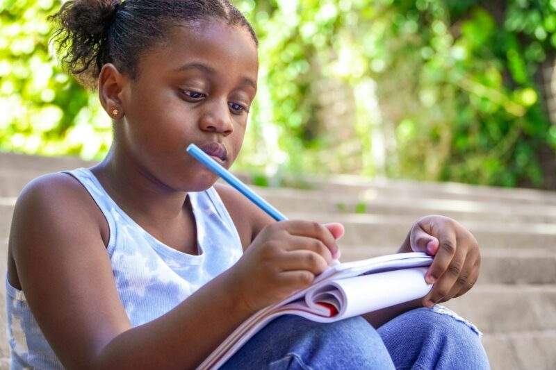 Black girl writing on her notebook