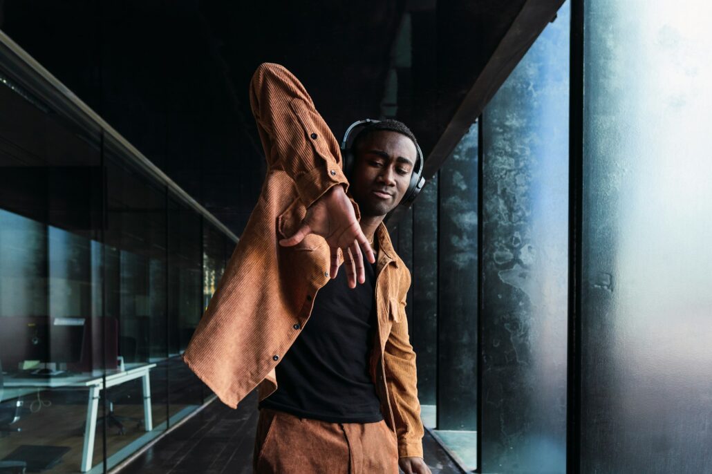 Black man listening to music near building