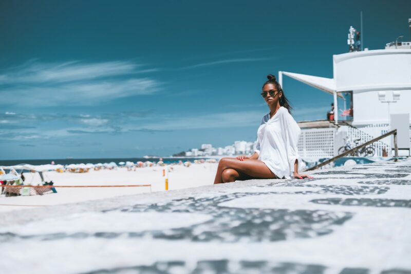 Black young female in sunglasses near beach