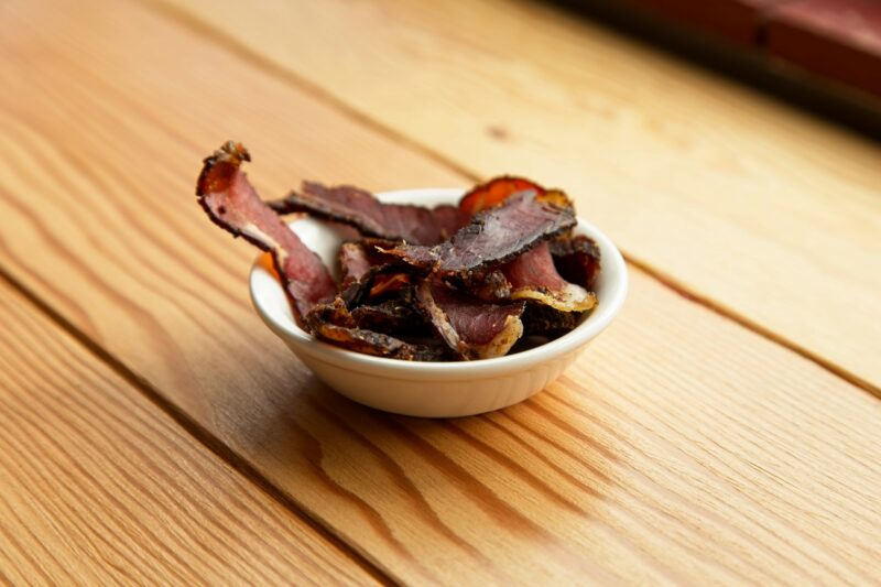 Bowl of traditional South African biltong on a wooden surface