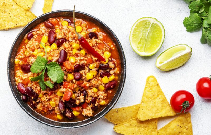 Chili con carne, mexican dish with minced beef, red beans, paprika, corn and hot peppers