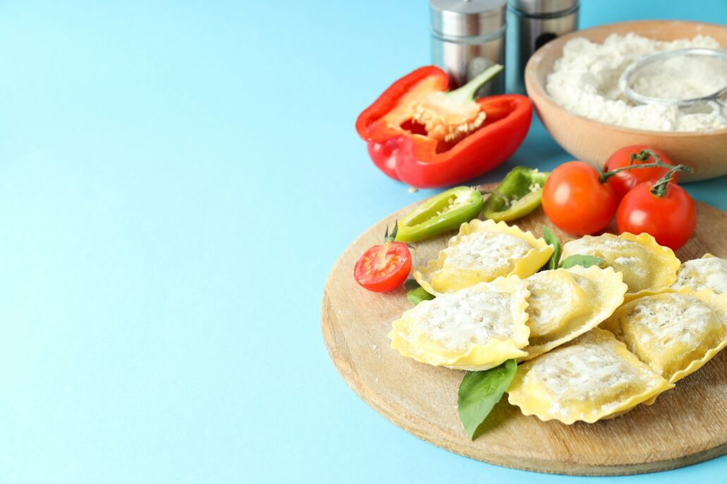 Concept of cooking ravioli on blue background