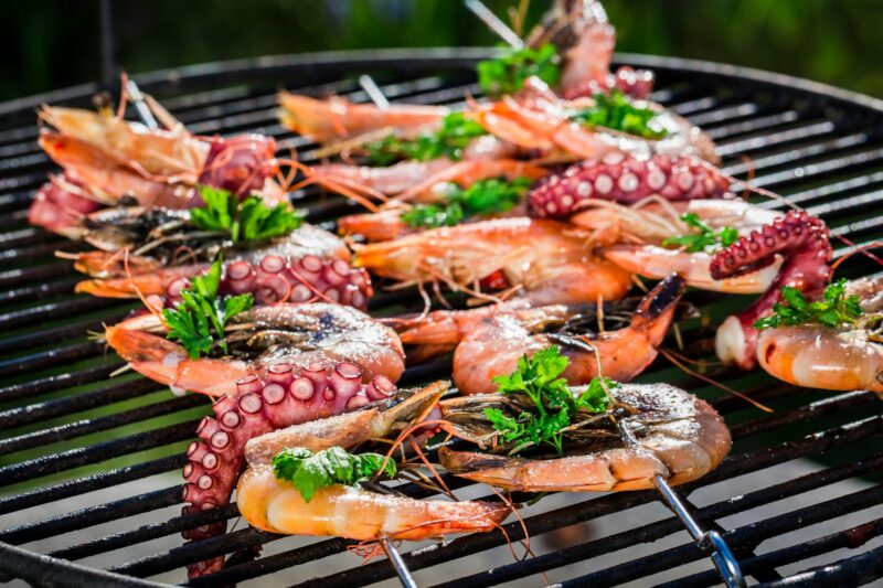 Fresh seafood skewers with lemon and parsley for grilling