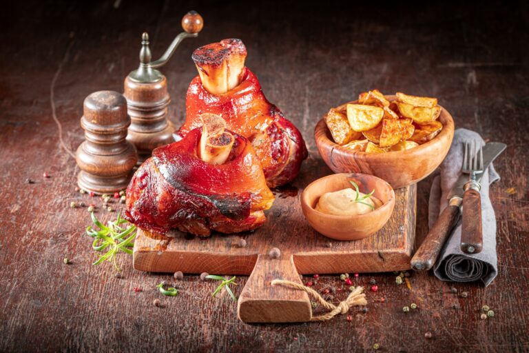 Grilled roasted Schweinshaxe served with potatoes and pickled cabbage.