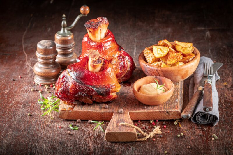 Grilled roasted Schweinshaxe served with potatoes and pickled cabbage.