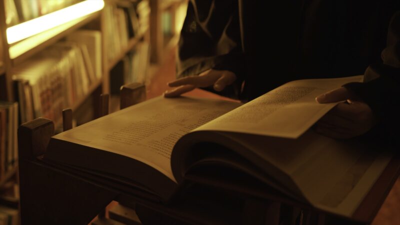 Man reading large mysterious book. Stock footage. Close-up of mysterious man reading ancient