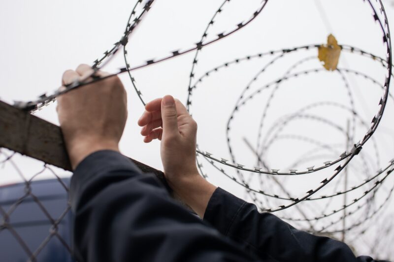 Men's hands on the background of barbed wire