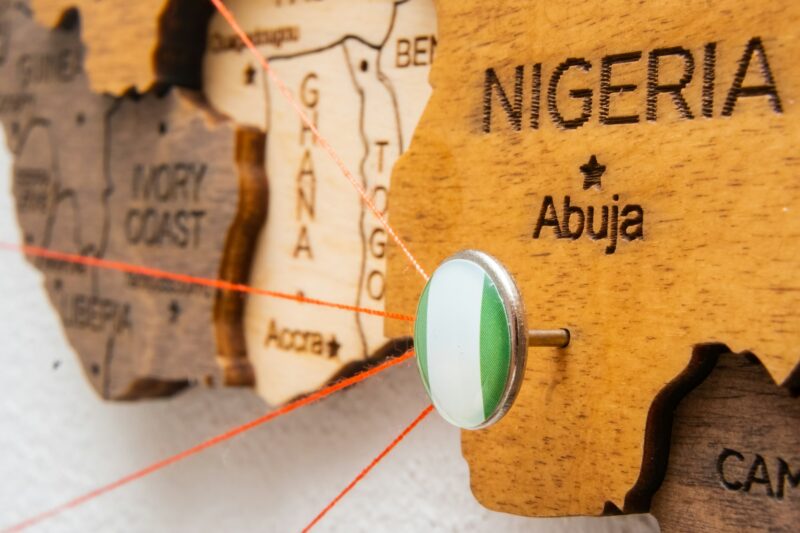 Nigeria flag on the pin with red thread showed the paths on the wooden map.