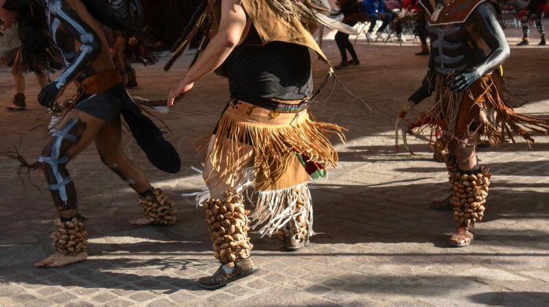 People dancing traditional dance in Mexico with Aztec clothing