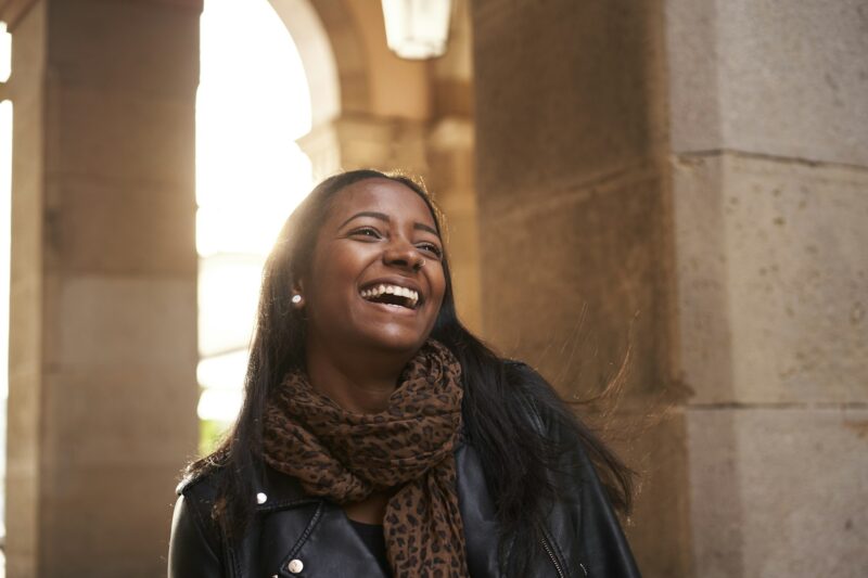 Portrait of an African American black woman laughing outdoors.