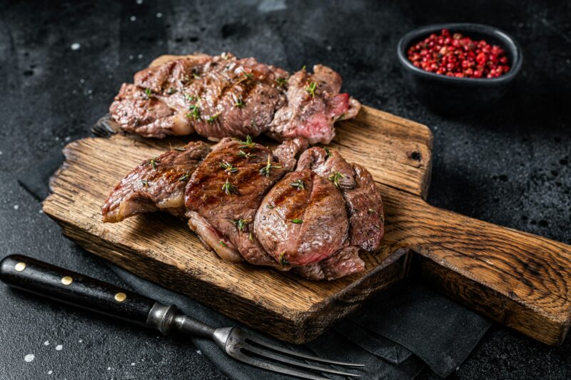 Rost Lamb leg fillet steaks, mutton meat with spices. Black background. Top view