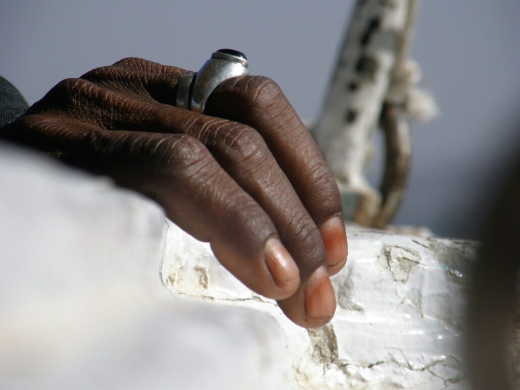 Selective focus shot of a male hand with a ring on the old boat