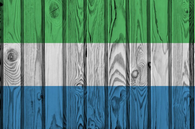 Sierra Leone flag depicted in bright paint colors on old wooden wall close up